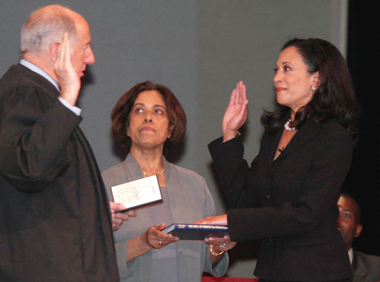 San Francisco's new district attorney, Kamala Harris, right, receives the oath of office from California Supreme Court Chief Justice Ronald M. George, left, during inauguration ceremonies Thursday, Jan. 8, 2004, in San Francisco. In the center is Harris' mother, Dr. Shyamala Gopalan, who holds a copy of "The Bill of Rights." (George Nikitin/AP)