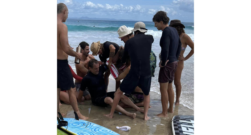 Beach goers helping to save Matthew Cassidy.