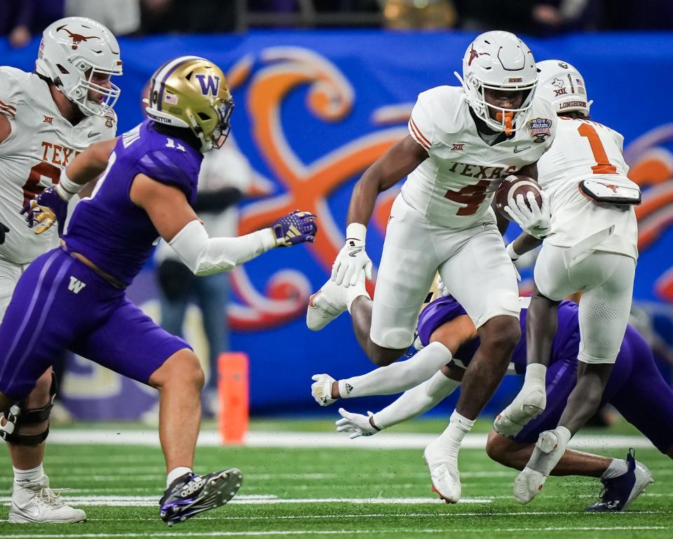 Texas' CJ Baxter evades the Washington defense during the Huskies' win in the CFP semifinals. Baxter returns as part of a deep group of running backs that includes Jaydon Blue and a couple of promising freshmen.