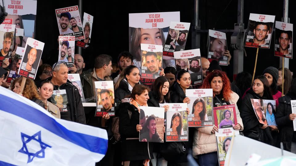 Families of hostages and former hostages hold images on a podium at a protest near the International Crime Court at The Hague, Netherlands, on Wednesday. - Martin Meissner/AP