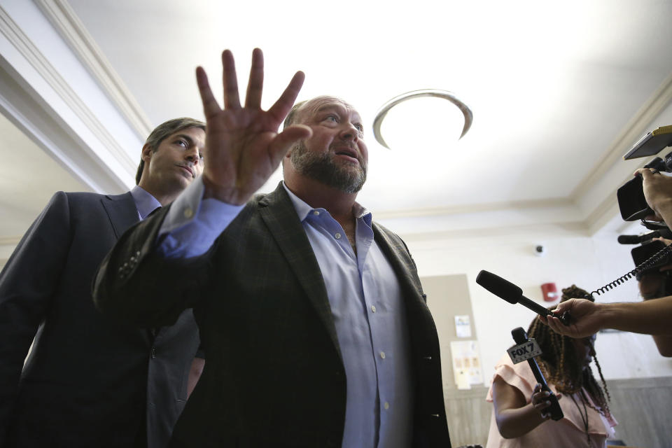 Alex Jones talks to media during a midday break during the trail at the Travis County Courthouse in Austin, Texas, Tuesday, July 26, 2022. An attorney for the parents of one of the children who were killed in the Sandy Hook Elementary School shooting told jurors that Jones repeatedly “lied and attacked the parents of murdered children” when he told his Infowars audience that the 2012 attack was a hoax. Attorney Mark Bankston said during his opening statement to determine damages against Jones that Jones created a “massive campaign of lies” and recruited “wild extremists from the fringes of the internet ... who were as cruel as Mr. Jones wanted them to be" to the victims' families. Jones later blasted the case, calling it a “show trial” and an assault on the First Amendment. (Briana Sanchez/Austin American-Statesman via AP, Pool)
