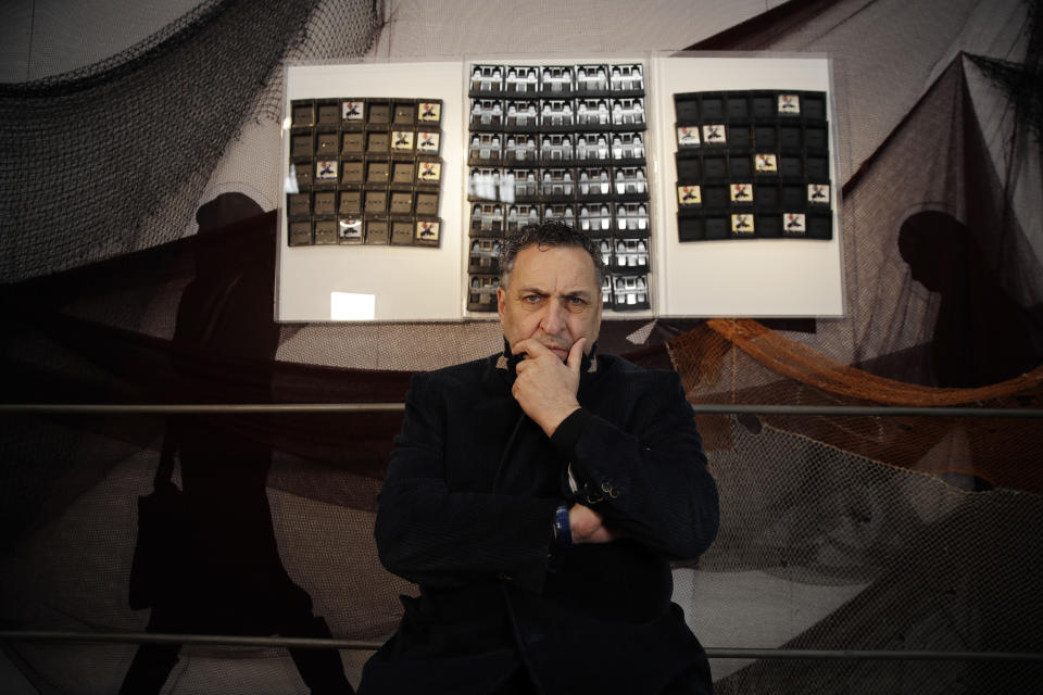 In this picture taken on Friday, April 12, 2019, Italian photographer Maurizio Galimberti, poses next to his creation made with Polaroid unused cartridges, at the National Museum of Science and Technology, during the "RO Plastic - Master's Pieces" exhibition', on the sidelines of the Salone del Mobile International Furniture Fair week, in Milan, Italy. Scientists and environmental activists have been long raised the alarm on plastic pollution. Now, the high-end design world is getting in on the growing global effort to tackle plastic pollution -- by upcycling discarded objects into desirable one-off design pieces. (AP Photo/Luca Bruno)