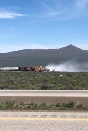 Smoke rises from overturned train wagons after an accident near Wells