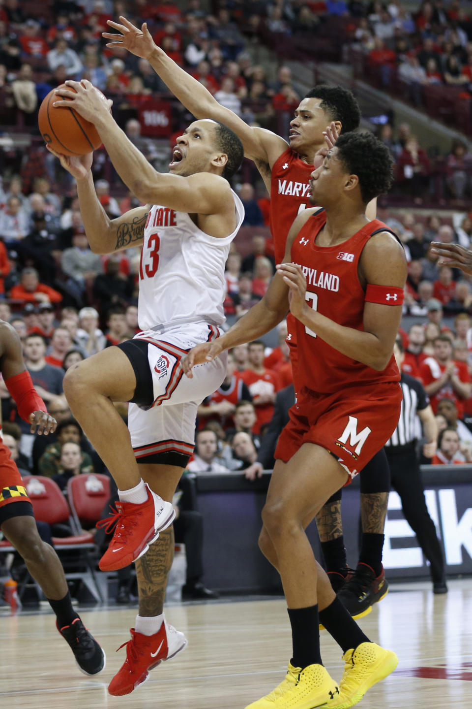 Ohio State's C.J. Walker, left, takes a shot between Maryland's Anthony Cowan, center, and Aaron Wiggins during the second half of an NCAA college basketball game Sunday, Feb. 23, 2020, in Columbus, Ohio. Ohio State defeated Maryland 79-72. (AP Photo/Jay LaPrete)