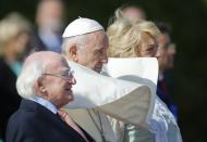 Pope Francis, center, is flanked by Irish President Michael D. Higgins, left, and President's wife Sabina, upon his arrival at the Presidential residence in Dublin, Ireland, Saturday, Aug. 25, 2018. Pope Francis is on a two-day visit to Ireland. (AP Photo/Peter Morrison)