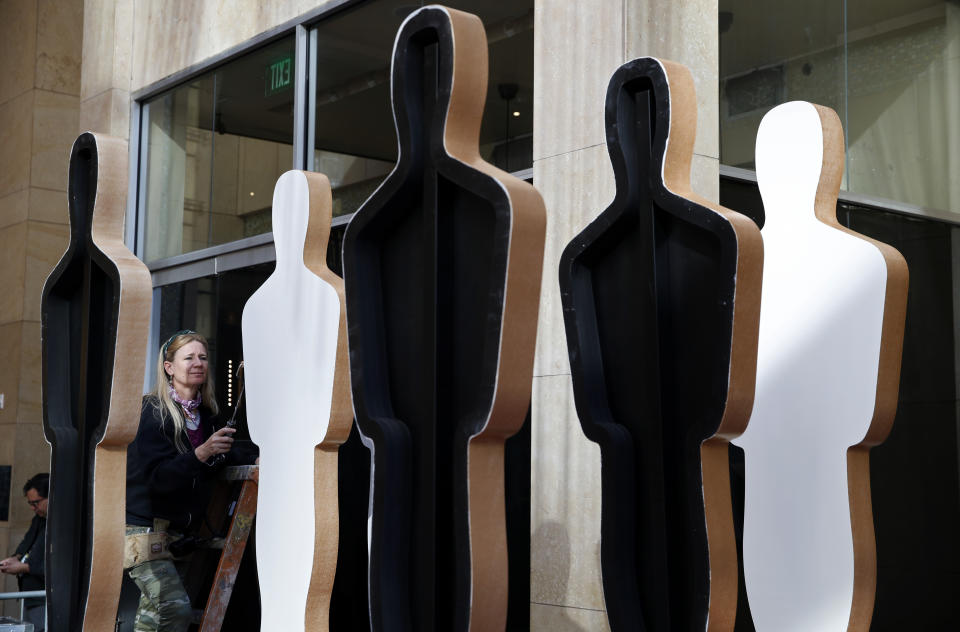 A worker paints Oscar statues in preparation for Sunday's red carpet arrivals at the 92nd Academy Awards at the Dolby Theatre, Friday, Feb. 7, 2020, in Los Angeles. (AP Photo/John Locher)