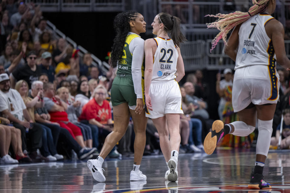 Seattle Storm guard Victoria Vivians, left, and Indiana Fever guard Caitlin Clark (22) exchange words after making contact with one another during the first half of a WNBA basketball game Thursday, May 30, 2024, in Indianapolis. (AP Photo/Doug McSchooler)