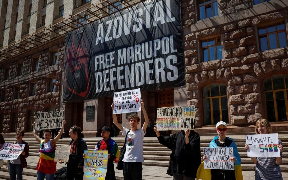 Participants hold placards as they attend a rally against discrimination of the LGBT+ community, amid Russia's attack on Ukraine, in Kyiv, Ukraine, May 17, 2024.