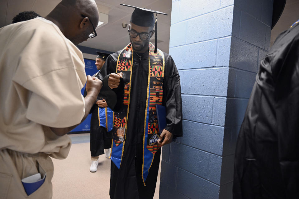 Graduate Marcus Harvin, right, fist bumps an inmate and fellow student at the first-ever college graduation ceremony at MacDougall-Walker Correctional Institution, Friday, June 9, 2023, in Suffield, Conn. The ceremony was held under a partnership established in 2021 by the University of New Haven and the Yale Prison Education Initiative. (AP Photo/Jessica Hill)