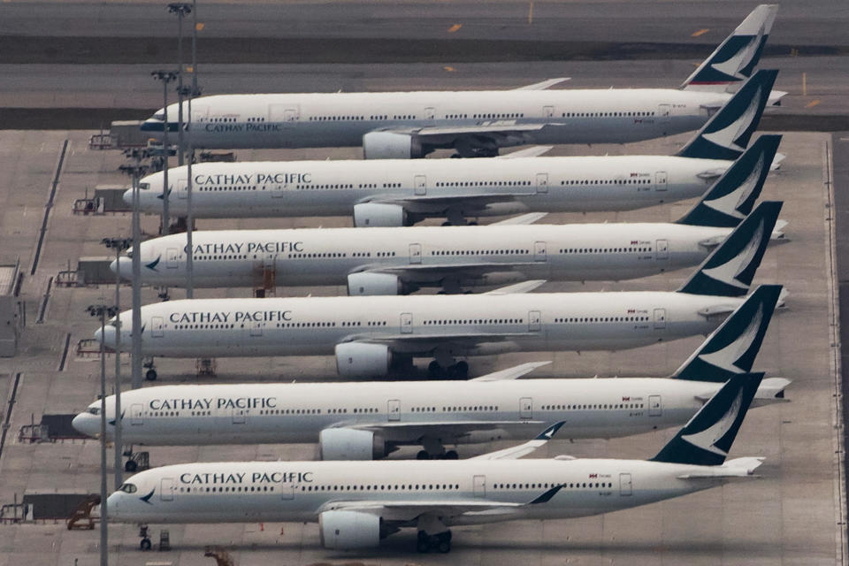 FILE - In this March 6, 2020, file photo, Cathay Pacific Airways aircrafts line up on the tarmac at the Hong Kong International Airport. Hong Kong airline Cathay Pacific Airways on Wednesday, Oct. 21, 2020, said it would cut 8,500 jobs and shut down its regional airline unit in a corporate restructuring, as it grapples with the plunge in air travel due to the pandemic. (AP Photo/Kin Cheung)