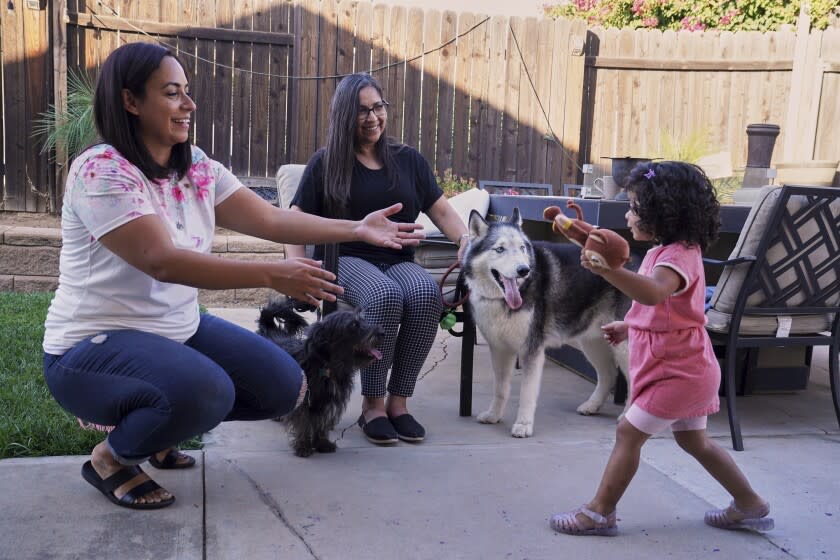 Laura Guerra (izquierda) y su hija Emilia, de 2 años, juegan en su hogar con su abuela Veronica, el lunes 11 de julio de 2022, en Riverside, California. (AP Foto/Damian Dovarganes)