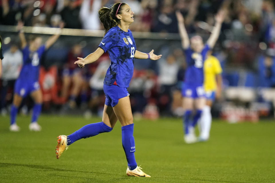 FILE - United States forward Alex Morgan (13) reacts to scoring a goal during the first half of a SheBelieves Cup soccer match against Brazil Wednesday, Feb. 22, 2023, in Frisco, Texas. The United States will be playing for an unprecedented three-peat at the Women's World Cup this summer. (AP Photo/LM Otero, FILE)