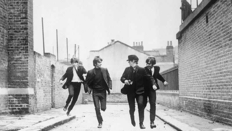 From left, Paul McCartney, George Harrison, John Lennon and Ringo Starr run down an empty London street in a scene from the 1964 movie “A Hard Day’s Night.”
