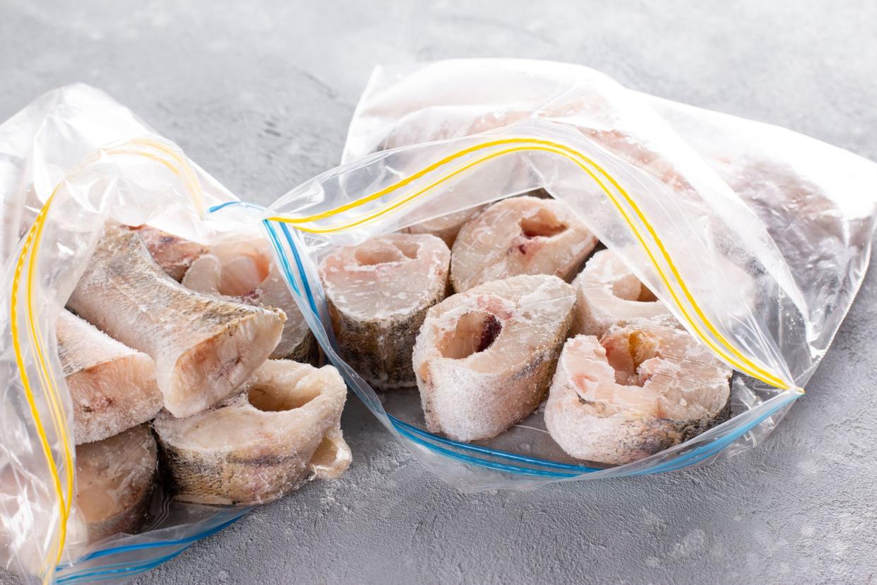 Frozen fish in a plastic bag on a light table. Frozen food