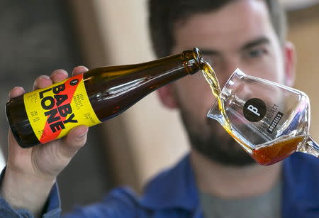 Sebastien Morvan, one of the founders of microbrewery Brussels Beer Project, serves a beer called Babylone at Barbeton bar in central Brussels, April 14, 2015. REUTERS/Yves Herman