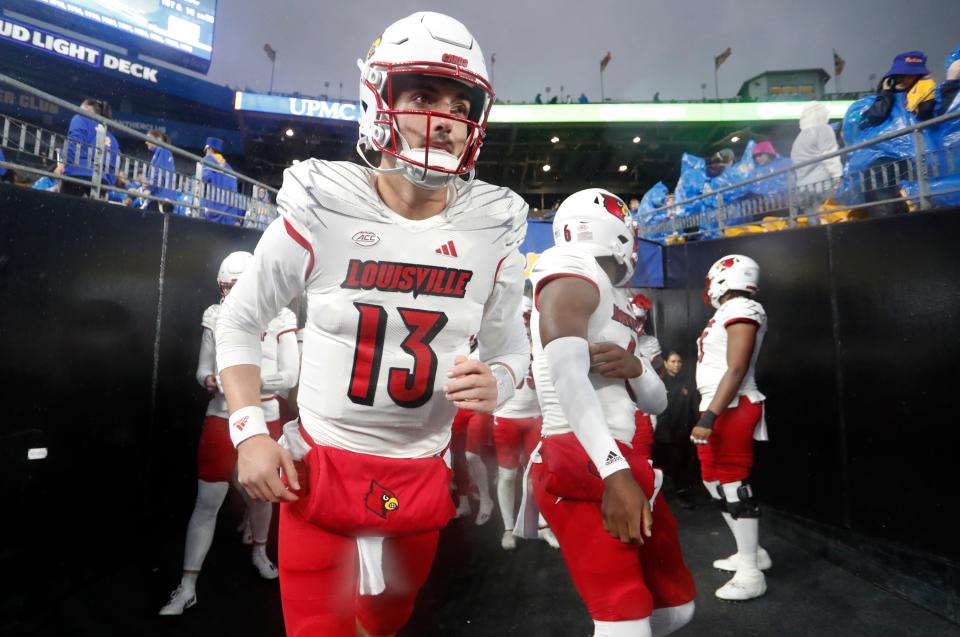 Oct 14, 2023; Pittsburgh, Pennsylvania, USA; Louisville Cardinals quarterback Jack Plummer (13) leads the team onto the field to play the Pittsburgh Panthers at Acrisure Stadium. Mandatory Credit: Charles LeClaire-USA TODAY Sports