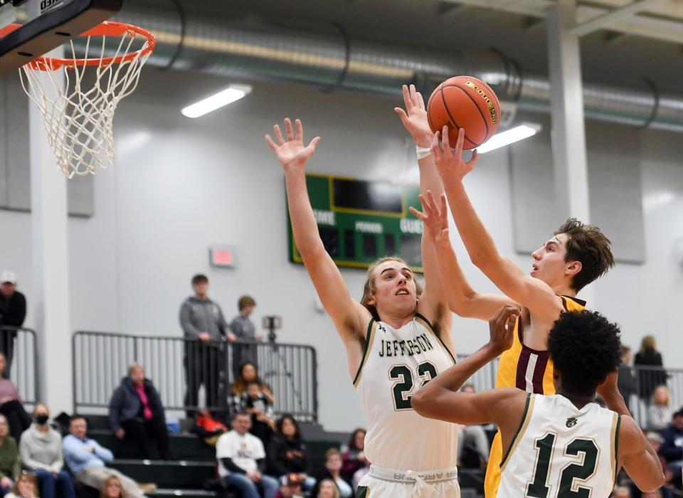 Harrisburg's Ethan Determan shoots a basket past Jefferson's Mason Riley and David Jones on Friday, January 21, 2022, at Jefferson High School in Sioux Falls.