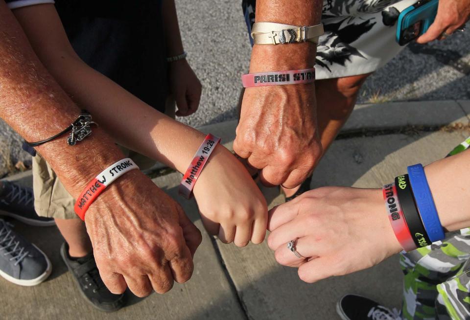 Donna Benfer, left, an aunt of Matthew Parisi; Conner Conley, 7, a cousin; Rebecca Rohrbach, an aunt; and Brianna Buckingham, his girlfriend wear their "Parisi Strong" bracelets Sunday.