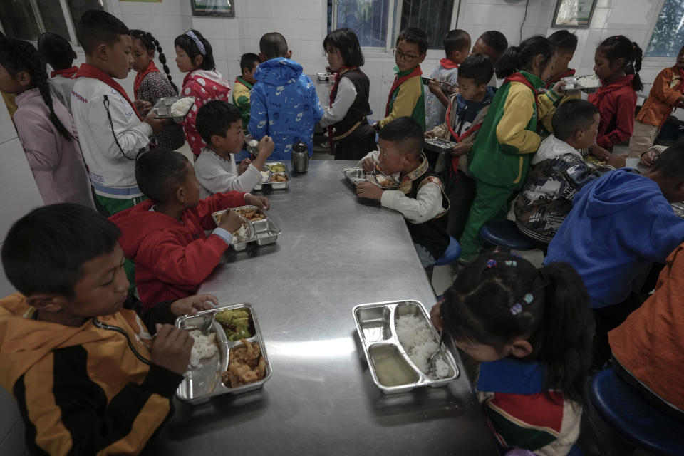 Tibetan students eat their meals at a canteen in the Shangri-La Key Boarding School during a media-organized tour in Dabpa county, Kardze Prefecture, Sichuan province, China on Sept. 5, 2023. (AP Photo/Andy Wong)