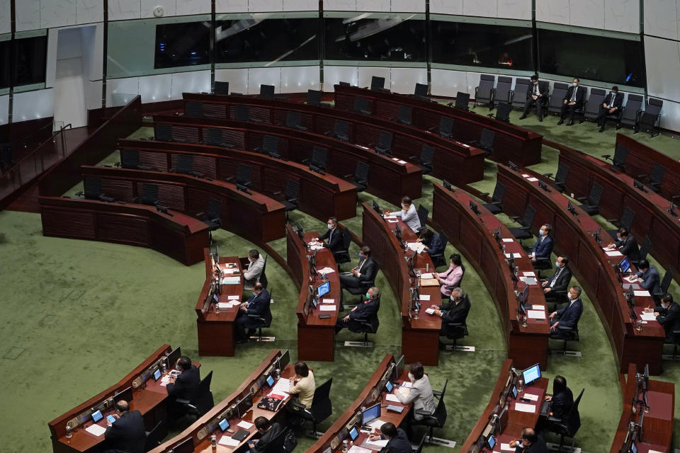 FILE - In this Nov. 25, 2020, file photo, empty seats of pro-democracy legislators, top, are seen as Hong Kong Chief Executive Carrie Lam delivers her policies at chamber of the Legislative Council in Hong Kong. A senior Chinese official says the largely pro-Beijing committee that currently elects the Hong Kong's leader will also elect some members of the city's legislature, as part of Beijing's planned revamp of Hong Kong's electoral system. (AP Photo/Kin Cheung, File)