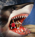 Children sit on a piece of 3D artwork featuring a shark as they pose for a photograph for their family during an exhibition by the Trick Art Museum of Japan at the National Taiwan Science Education Centre in Taipei March 2, 2012. The exhibition will be held in Taipei from March 3 to June 3, 2012. REUTERS/Shengfa Lin