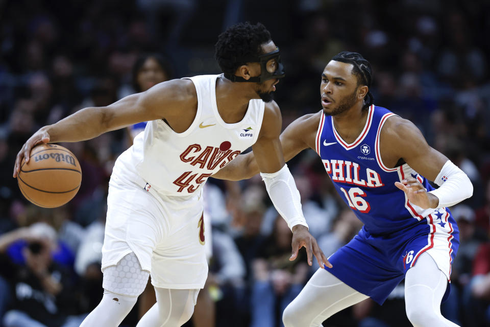 Cleveland Cavaliers guard Donovan Mitchell (45) is defended by Philadelphia 76ers guard Ricky Council IV (16) during the first half of an NBA basketball game Friday, March 29, 2024, in Cleveland. (AP Photo/Ron Schwane)