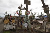 Children, who are victims of super typhoon Haiyan, decorate their improvised Christmas tree with empty cans and bottles at the ravaged town of Tanuan, Leyte province, central Philippines December 19, 2013. Super typhoon Haiyan reduced almost everything in its path to rubble when it swept ashore in the central Philippines on November 8, killing at least 6,069 people, leaving 1,779 missing and 4 million either homeless or with damaged homes. REUTERS/Romeo Ranoco (PHILIPPINES - Tags: DISASTER SOCIETY)