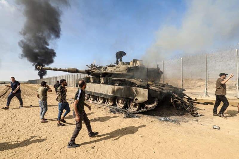 Palestinians take control of an Israeli tank after crossing the border fence with Israel from Khan Yunis. Israeli military intelligence sounded clear warnings regarding a pending attack more than two weeks before Hamas launched its attack from the Gaza Strip on October 7 last year, according to Kan, the Israeli Public Broadcasting Corporation. Abed Rahim Khatib/dpa