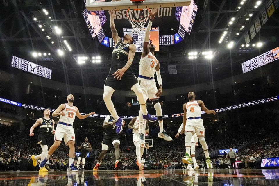 Milwaukee Bucks' George Hill shoots past New York Knicks' Nerlens Noel during the first half of an NBA basketball game Friday, Jan. 28, 2022, in Milwaukee. (AP Photo/Morry Gash)