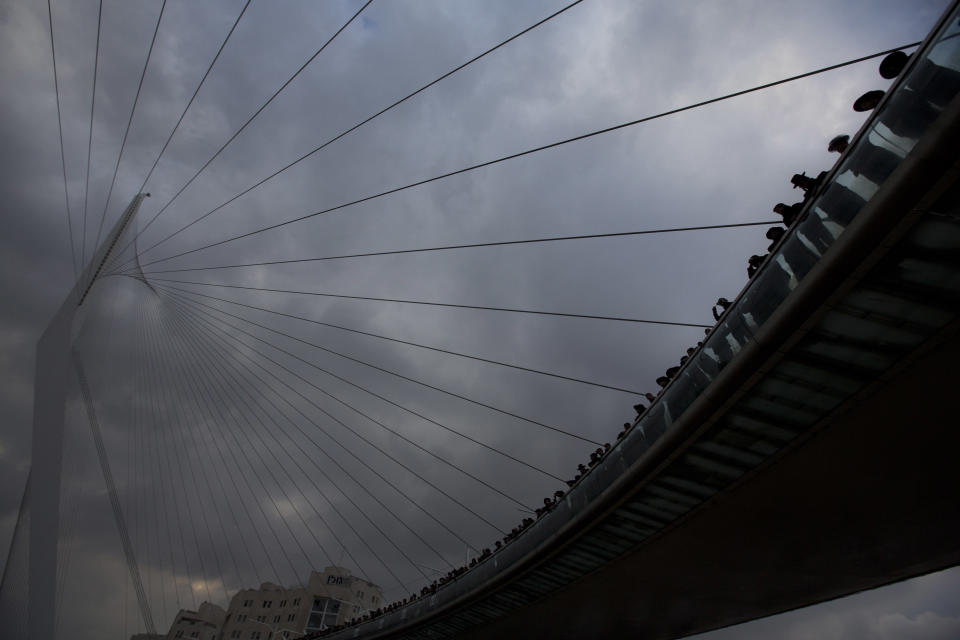 Ultra-Orthodox Jewish men stand on a bridge during a demonstration in Jerusalem, Thursday, Feb. 6, 2014. Israeli police said thousands of ultra-Orthodox Jews are blocking highways across the country to protest plans to enlist them into the military. (AP Photo/Sebastian Scheiner)