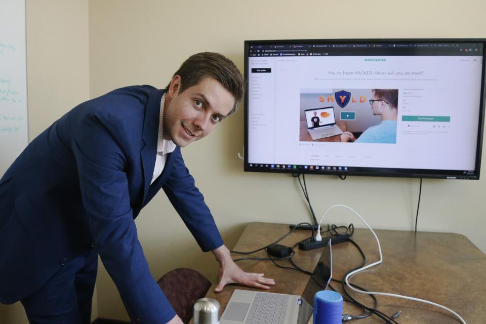 In this Aug. 27, 2019 photo, Tyler Olson poses in hits office at the University of St. Thomas Minneapolis campus. Olson is just starting a cybersecurity company. (AP Photo/Jim Mone)