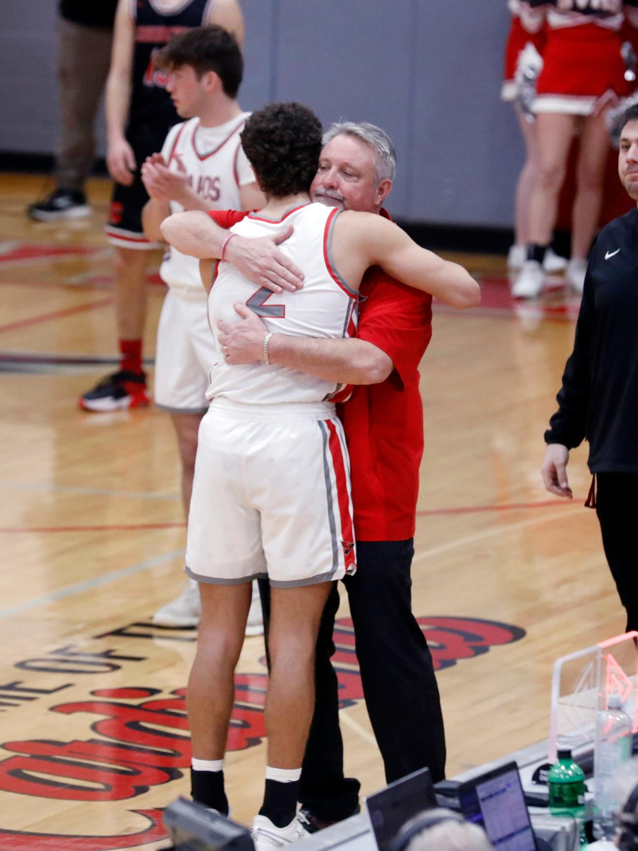 Sandy Valley senior Nick Petro, left, and head coach Gary Offenberger embrace late in the fourth quarter of a 47-38 loss to visiting Coshocton in a Division III sectional game on Tuesday in Sandyville. Petro had game highs of 16 points and nine rebounds as the Cardinals finished 16-7.