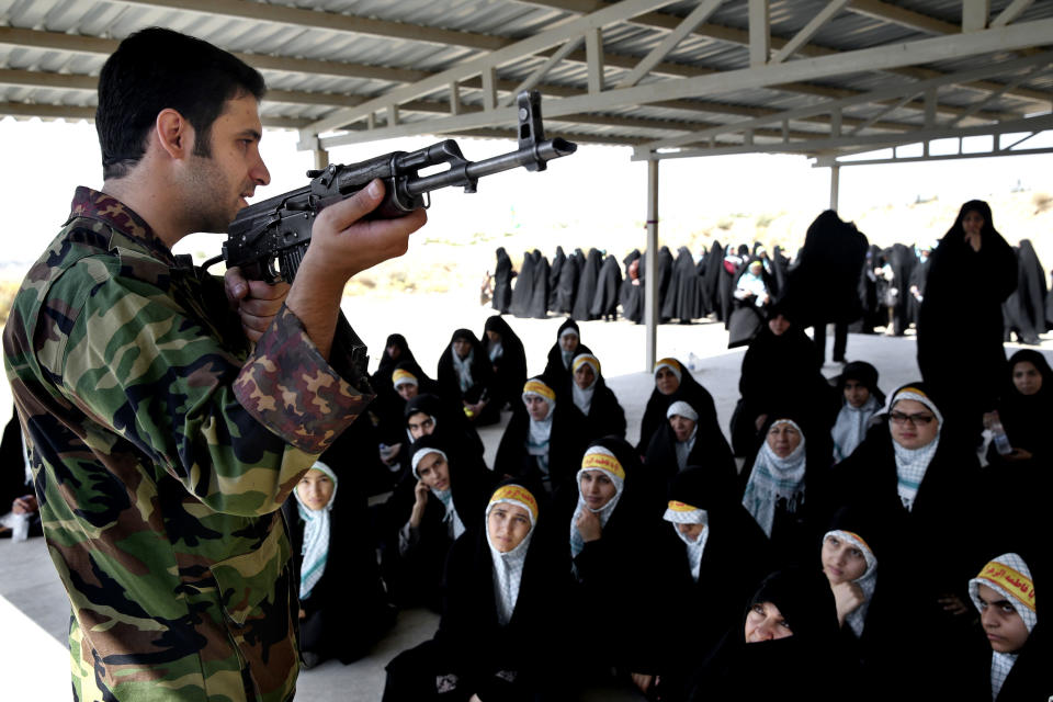 In this Thursday, Aug. 22, 2013 photo, a trainer of the Basij paramilitary militia shows female Basij members how to use an AK-47 rifle during a training session in Tehran, Iran. Authorities created the Basij, which means mobilization in Persian, just after the country’s 1979 Islamic Republic. It is part of Iran’s powerful Revolutionary Guard. (AP Photo/Ebrahim Noroozi)
