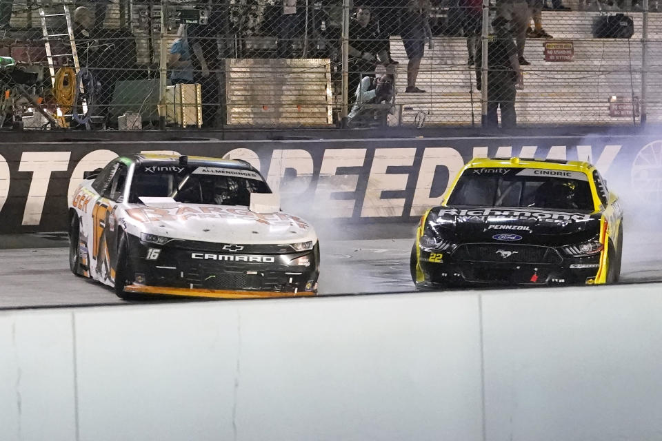 AJ Allmendinger, left, slides across the finish line ahead of Austin Cindric to win a NASCAR Xfinity Series auto race at Bristol Motor Speedway Friday, Sept. 17, 2021, in Bristol, Tenn. (AP Photo/Mark Humphrey)