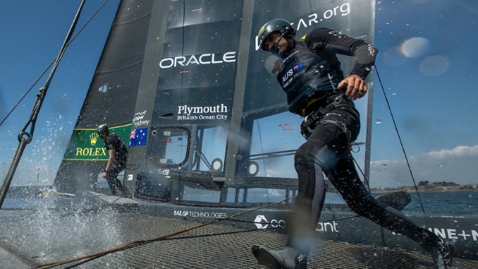 Driver Peter Burling sprinting across the boat during a maneuver. - Credit: Courtesy SailGP