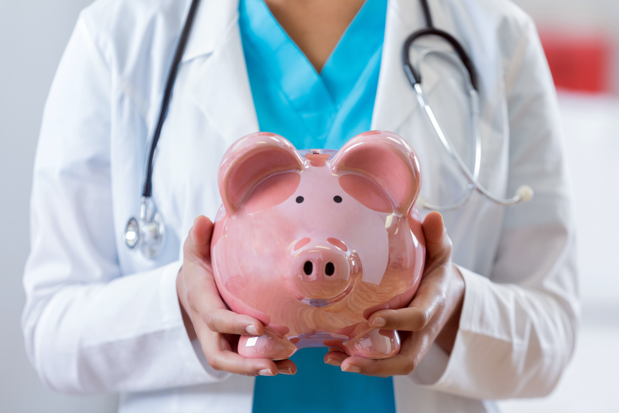 Doctor holding a piggy bank