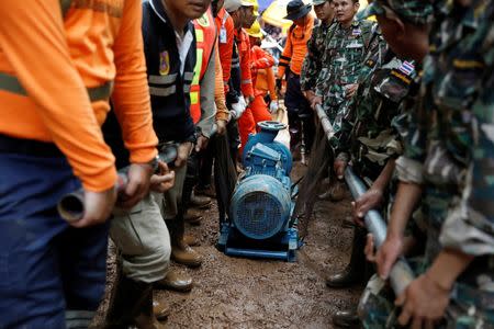 Soldiers and rescue workers carry a water pump to the Tham Luang cave complex June 28, 2018. REUTERS/Soe Zeya Tun