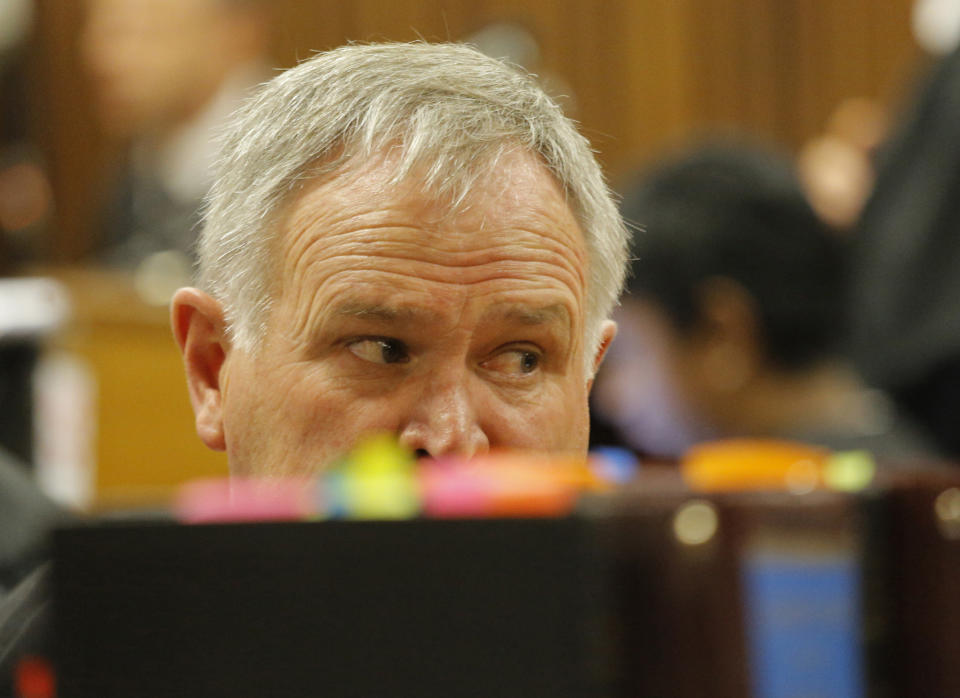 Barry Roux, defense attorney for Oscar Pistorius, listens as chief prosecutor Gerrie Nel questions Oscar Pistorius, in court in Pretoria, South Africa, Monday, April 14, 2014. The chief prosecutor in the murder trial of Oscar Pistorius on Monday accused him of tailoring his version of how he killed his girlfriend to fit evidence at the scene, exhaustively listing alleged inconsistencies in the athlete's account of the fatal shooting of Reeva Steenkamp. (AP Photo/Kim Ludbrook, Pool)