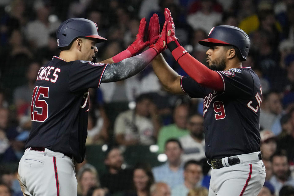 Washington Nationals' Jeimer Candelario, right, celebrates with Joey Meneses after hitting a solo home run during the eighth inning of a baseball game against the Chicago Cubs in Chicago, Wednesday, July 19, 2023. (AP Photo/Nam Y. Huh)