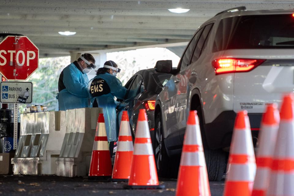 People come to be tested Dec. 3 for COVID-19 at a county-run test site in a parking lot at Bergen Community College in Paramus, New Jersey. The state is on track to hit a coronavirus milestone by the end of the year with 1 in 500 residents dead due to the virus.