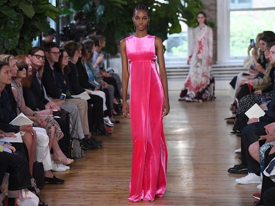 <p>Sportliche Elemente trafen in der Zwischenkollektion von Valentino auf Romantik: Mehr als jemals zuvor spielte Designer Pierpaolo Piccioli mit Gegensätzen. So präsentierte zum Beispiel dieses Model eine neonpinke Samt-Robe mit modernen Cut-outs. (Bild-Copyright: Getty Images via Yahoo Canada) </p>