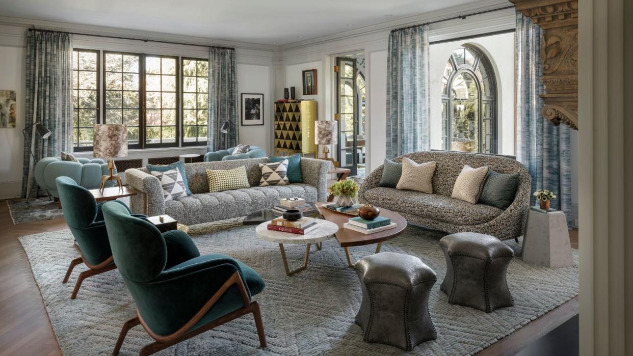  living room with blue chairs and two white sofas with windows on two sides 