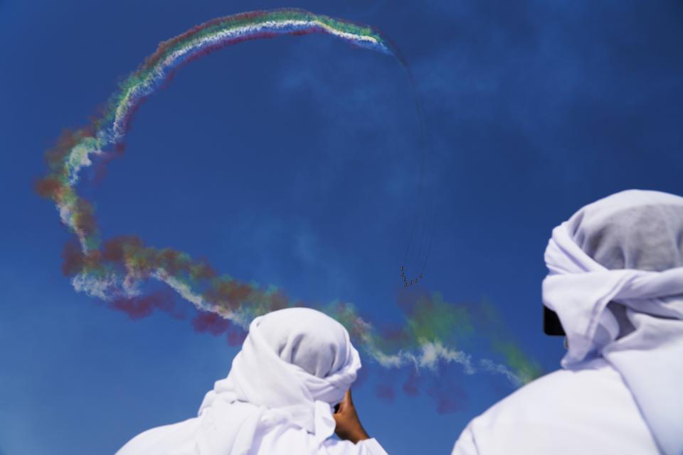 Emiratis watch as Al Fursan, the United Arab Emirates Air Force's aerobatic team, performs at the Dubai Air Show in Dubai, United Arab Emirates, Wednesday, Nov. 17, 2021. (AP Photo/Jon Gambrell)