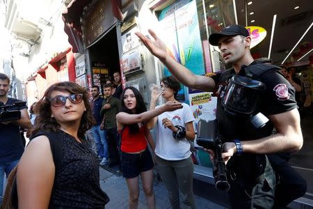 A riot police officer argues with people as LGBT rights activists try to gather for a pride parade, which was banned by the governorship, in central Istanbul, Turkey, June 25, 2017. REUTERS/Murad Sezer