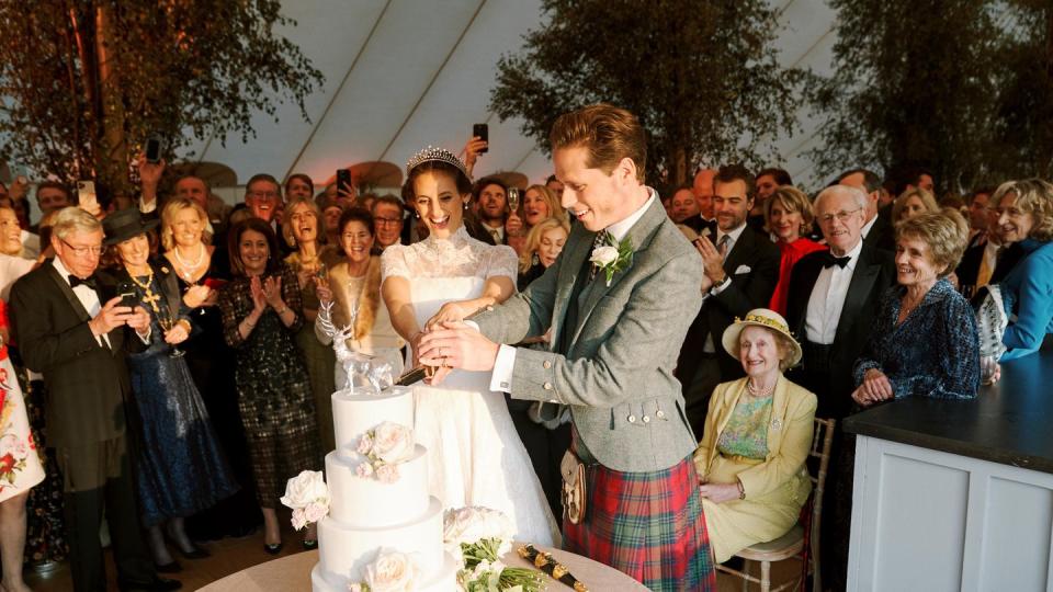 a bride and groom cutting their wedding cake