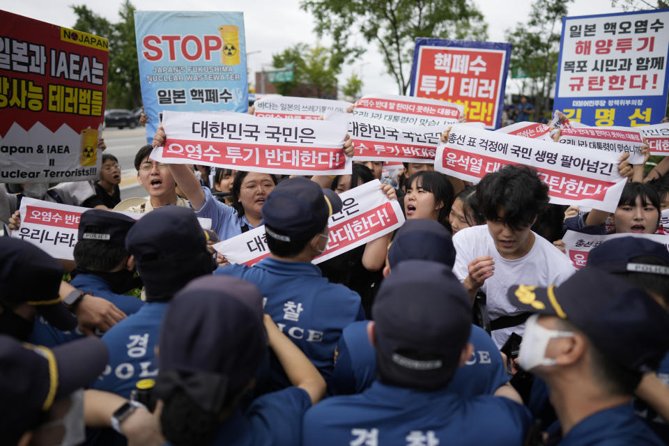 Protesters hold signs during a rally to denounce to release treated radioactive water into the sea from the damaged Fukushima nuclear power plant, outside of a building which houses Japanese Embassy, in Seoul, South Korea, Thursday, Aug. 24, 2023. The operator of the tsunami-wrecked Fukushima Daiichi nuclear power plant says it has begun releasing its first batch of treated radioactive water into the Pacific Ocean — a controversial step, but a milestone for Japan's battle with the growing radioactive water stockpile. The letters read "Oppose to release radioactive water." (AP Photo/Lee Jin-man)