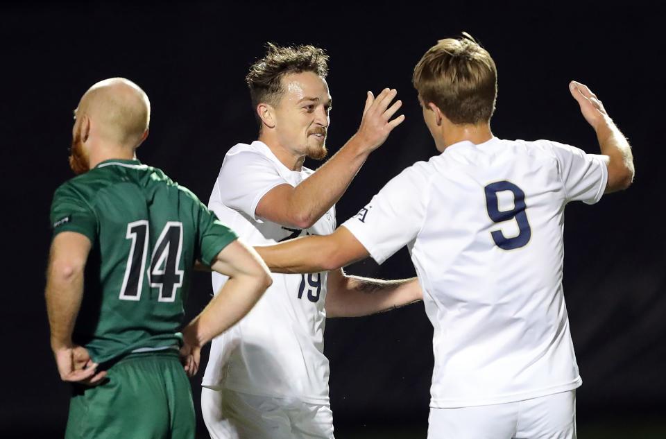 Akron midfielder Dyson Clapier (19) celebrates with Akron forward Jason Shokalook (9) after a goal against Cleveland State during the first half of an NCAA college soccer game, Tuesday, Oct. 25, 2022, in Akron, Ohio.