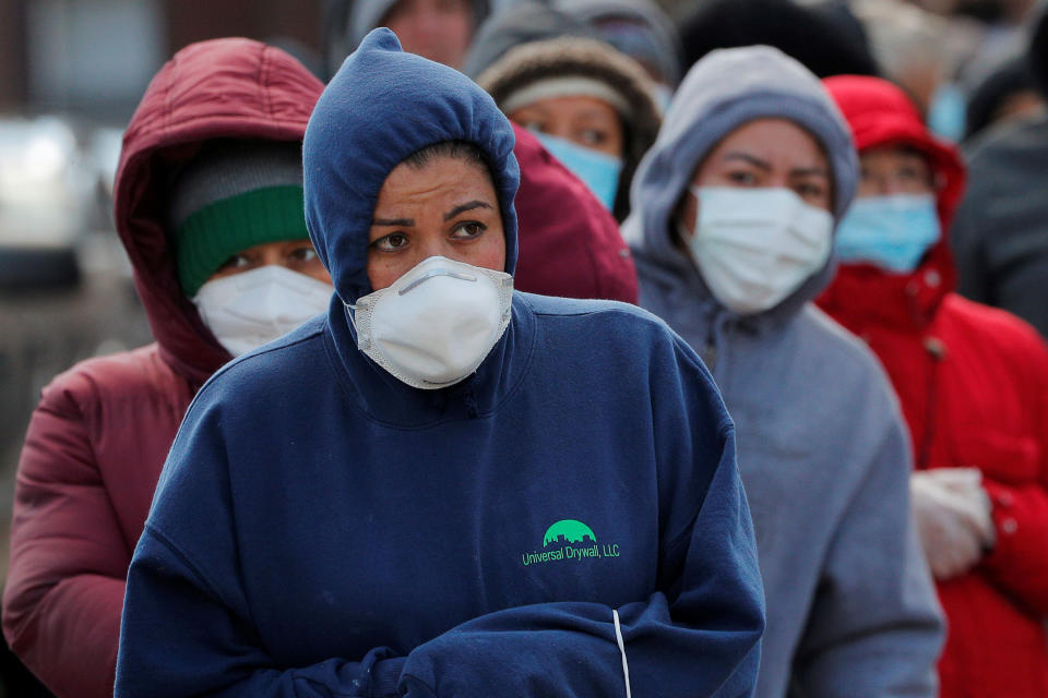 People wait in a line that wraps around the block in Chelsea, Massachusetts, for a pop-up food pantry amid the pandemic on April 17. (Photo: Brian Snyder/Reuters)