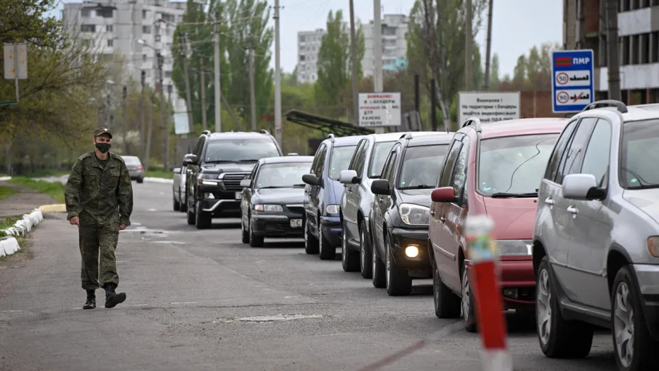 A Transnistrian serviceman walks past a line of cars queuing to cross the border into Moldova.