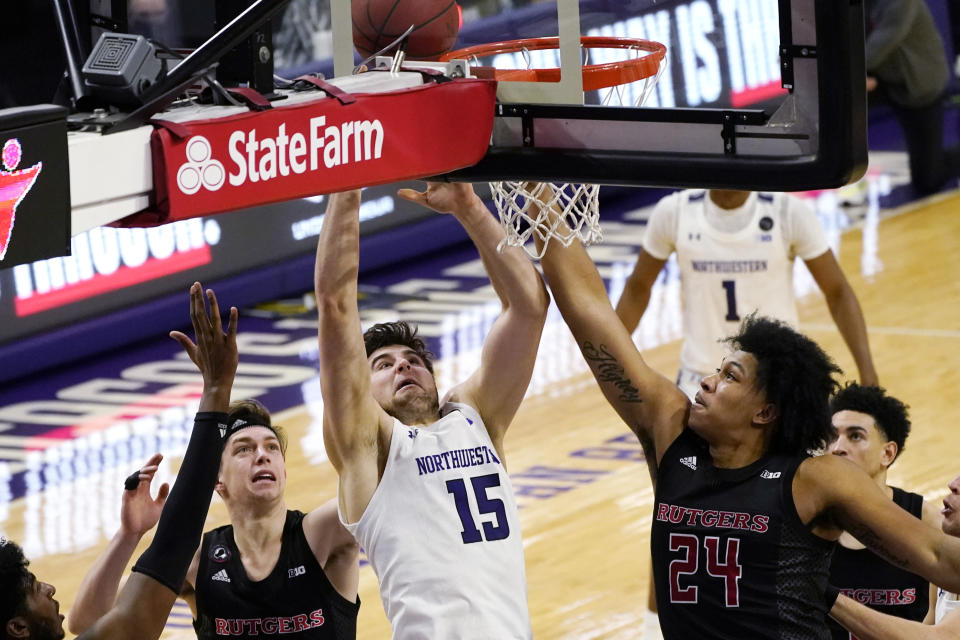 Northwestern center Ryan Young, center, shoots against Rutgers guard Paul Mulcahy, left, and guard/forward Ron Harper Jr., during the second half of an NCAA college basketball game in Evanston, Ill., Sunday, Jan. 31, 2021. (AP Photo/Nam Y. Huh)